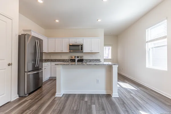 a kitchen with stainless steel appliances granite countertop a sink stove and cabinets