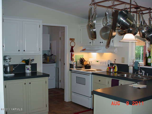 3240 Rosenkranz Road Tieton, WA 98947 - Photo 5 of 14 a kitchen with a sink dishwasher and a stove with wooden floor