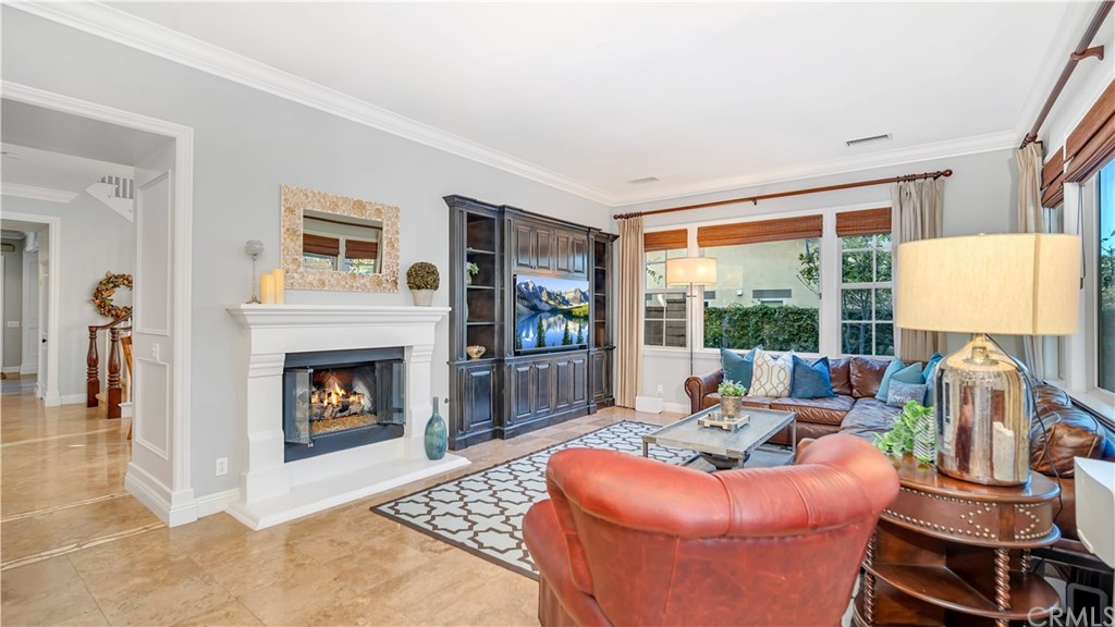 3 Adele Street Ladera Ranch, CA 92694 - Photo 7 of 42 a living room with furniture a fireplace and a floor to ceiling window