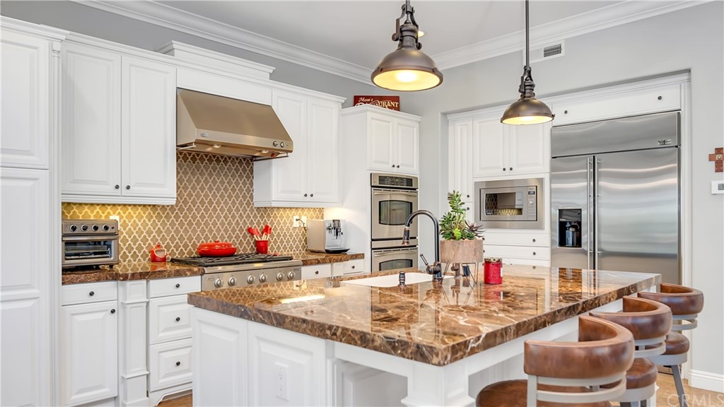 3 Adele Street Ladera Ranch, CA 92694 - Photo 8 of 42 a kitchen with stainless steel appliances granite countertop a sink and white cabinets