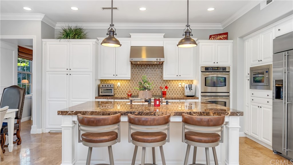 3 Adele Street Ladera Ranch, CA 92694 - Photo 9 of 42 a kitchen with stainless steel appliances granite countertop a stove and a refrigerator with white cabinets