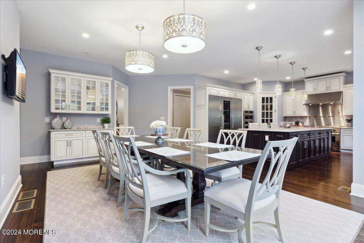 34 Windermere Road Lincroft, NJ 07738 - Photo 22 of 78 a view of a dining room and livingroom with furniture wooden floor a rug and a chandelier