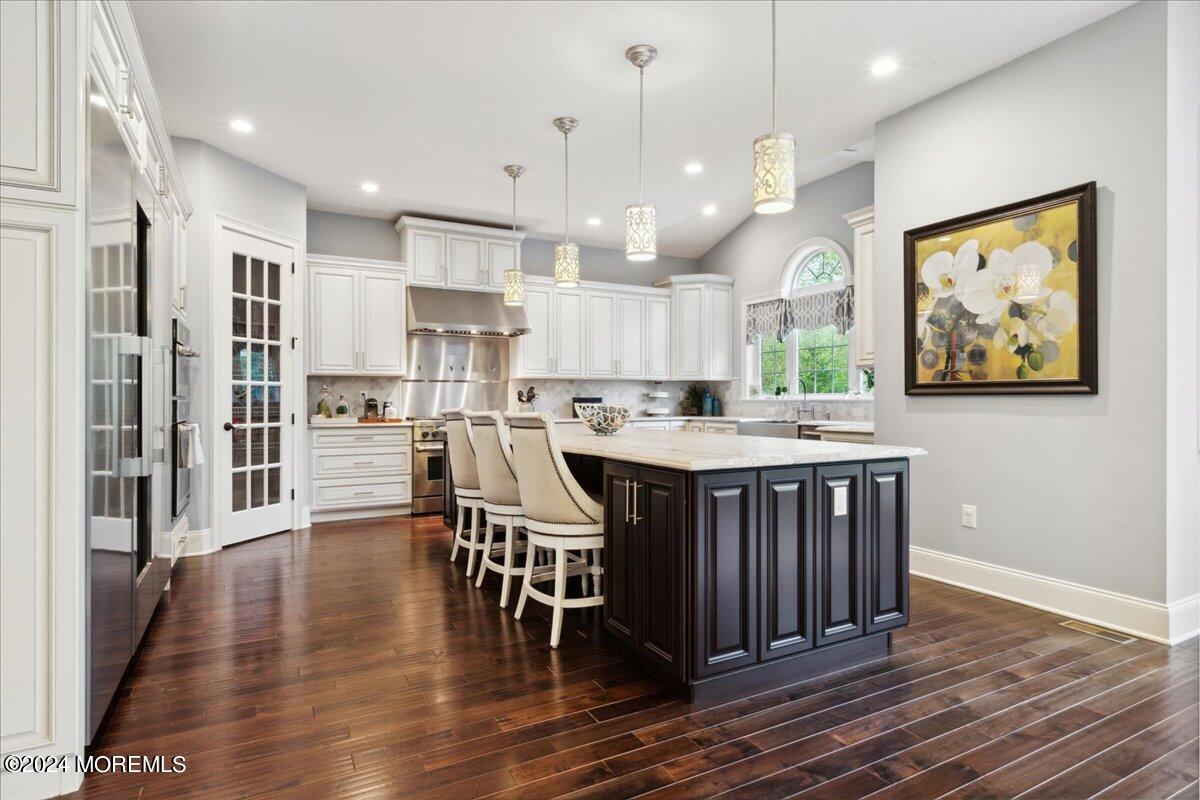 34 Windermere Road Lincroft, NJ 07738 - Photo 24 of 78 a kitchen with stainless steel appliances granite countertop a stove a refrigerator a sink dishwasher and a dining table with wooden floor