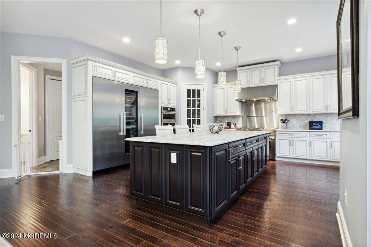34 Windermere Road Lincroft, NJ 07738 - Photo 30 of 78 a kitchen with kitchen island granite countertop a sink cabinets and wooden floor