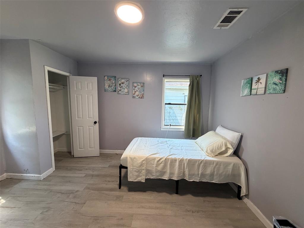 513 Shawnee Trace Grand Prairie, TX 75051 - Photo 22 of 32 Bedroom featuring wood-finish flooring, a window with blinds, a closet with shelving, and an overhead light fixture