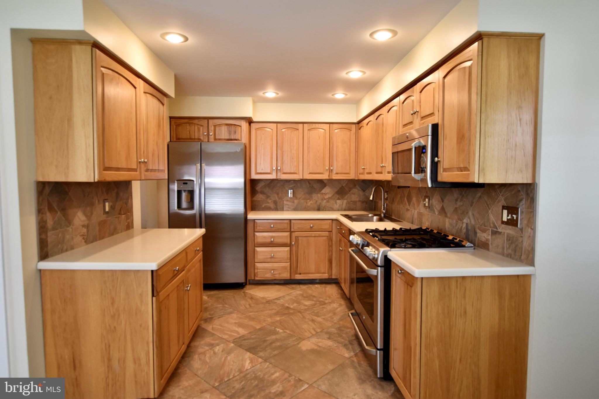 44 West Brookline Drive Laurel Springs, NJ 08021 - Photo 7 of 39 a kitchen with stainless steel appliances granite countertop a stove a sink a refrigerator a microwave and cabinets