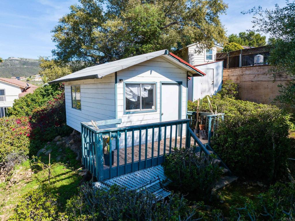 1628 Lone Oak Road Vista, CA 92084 - Photo 37 of 39 a view of a wooden house with a small yard plants and large trees