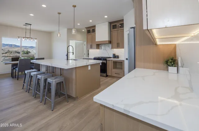 a large kitchen with kitchen island a sink table and chairs