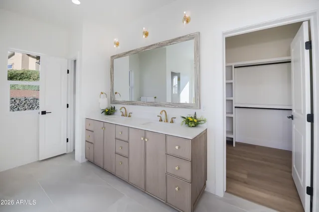 a spacious bathroom with a double vanity sink a mirror and a shower