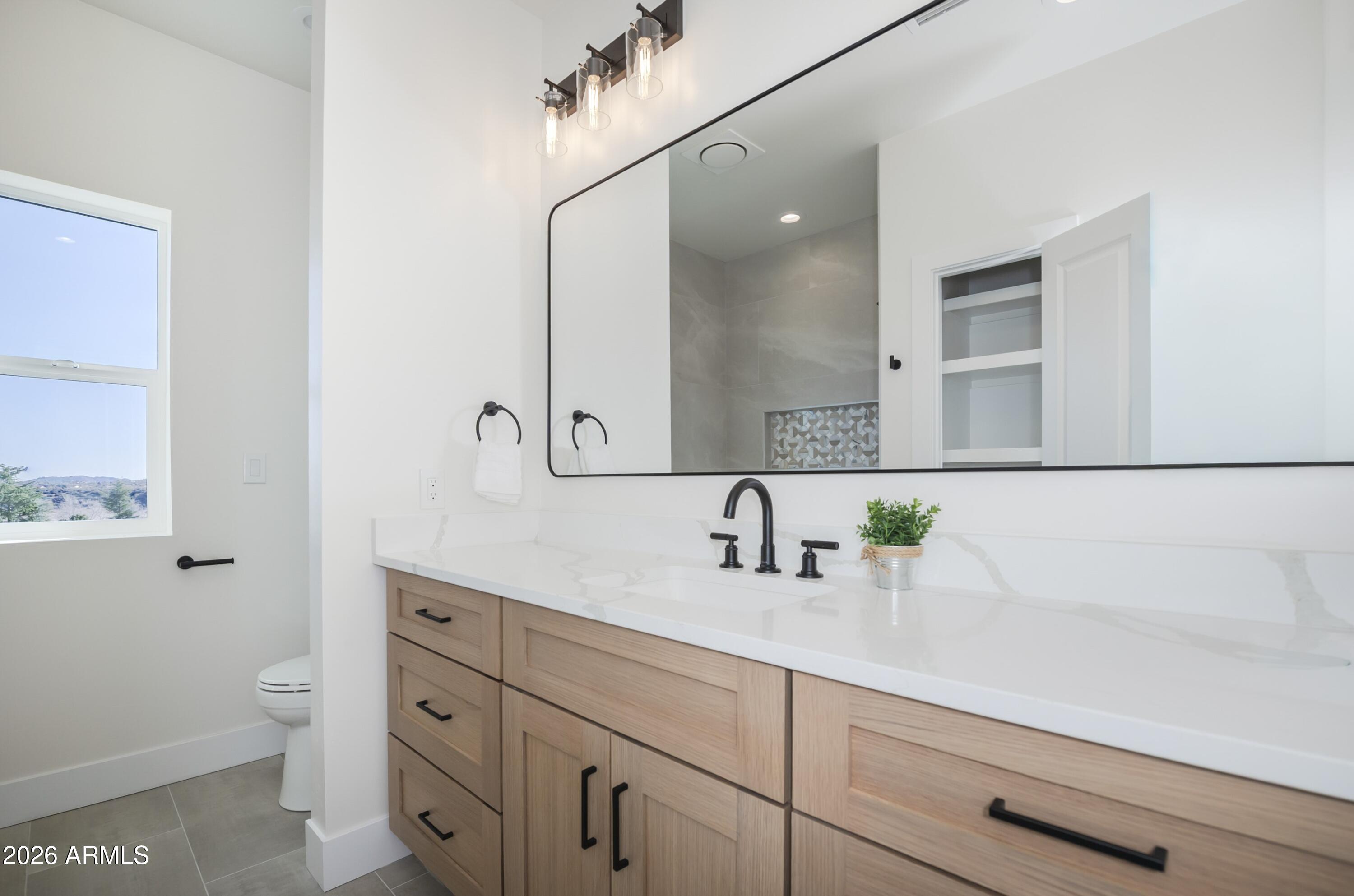10603 Straight Arrow Road Dewey, AZ 86327 - Photo 22 of 57 a bathroom with a sink a toilet and mirror