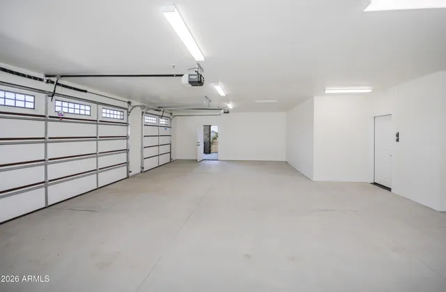 a view of an empty room with wooden floor and ceiling fan