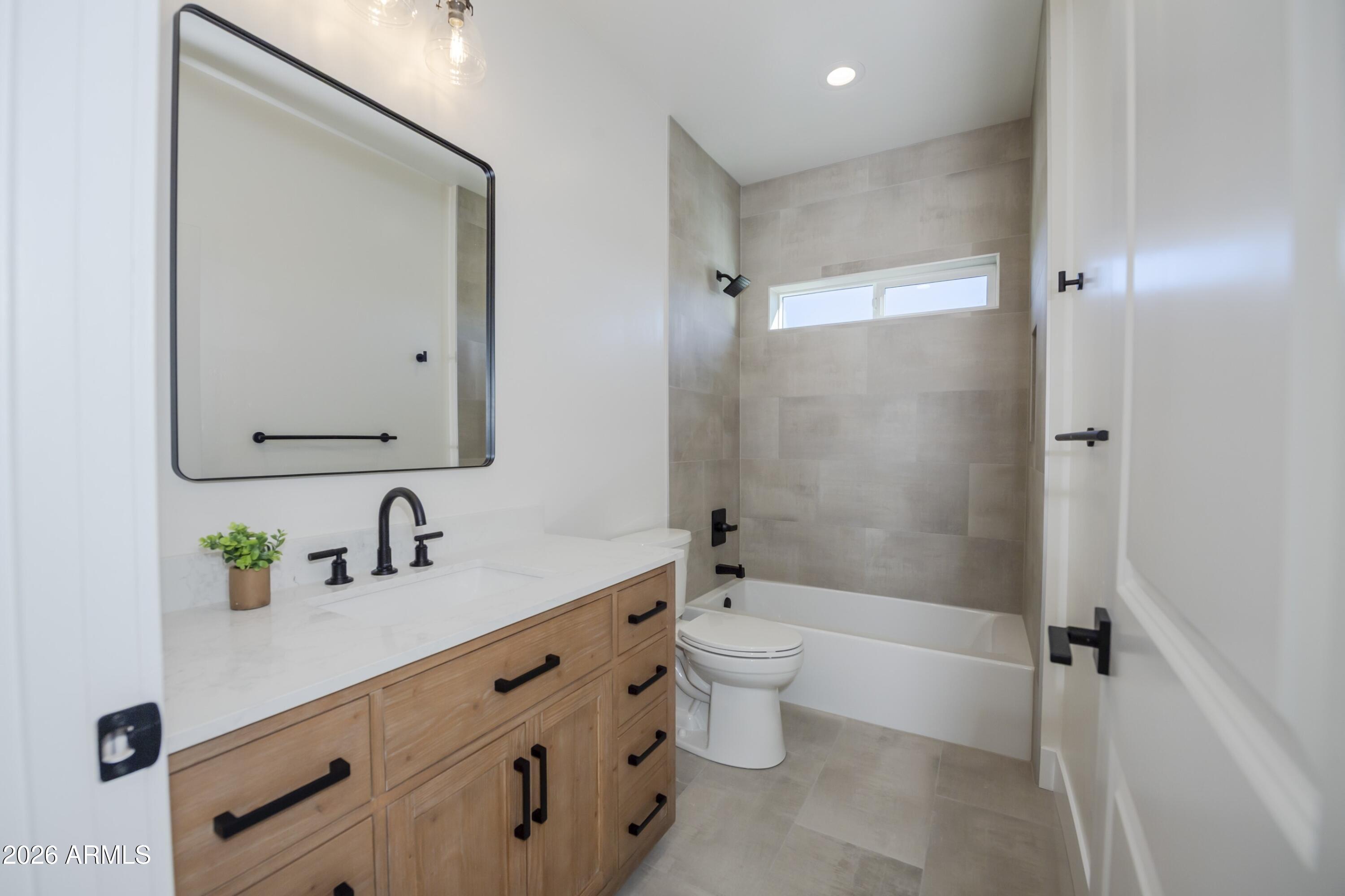 10603 Straight Arrow Road Dewey, AZ 86327 - Photo 36 of 57 a bathroom with a double vanity sink toilet mirror and shower