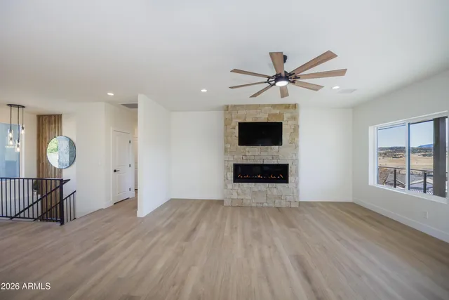 a view of an empty room with a kitchen and wooden floor