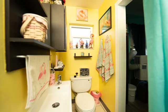 a bathroom with a granite countertop toilet sink and mirror