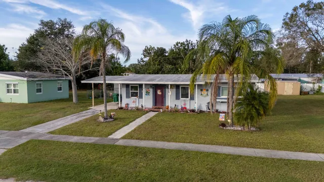 a front view of a house with a yard and trees