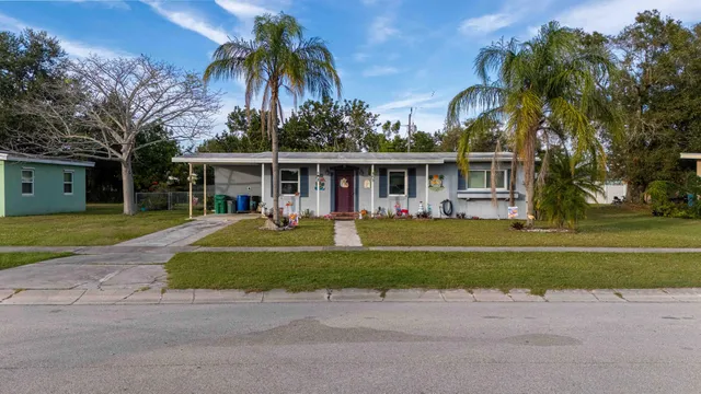 front view of a house with a swimming pool and a large trees
