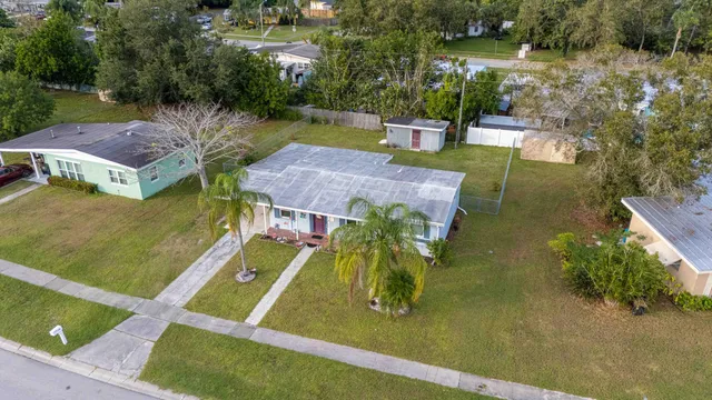 an aerial view of a house with a yard basket ball court and outdoor seating