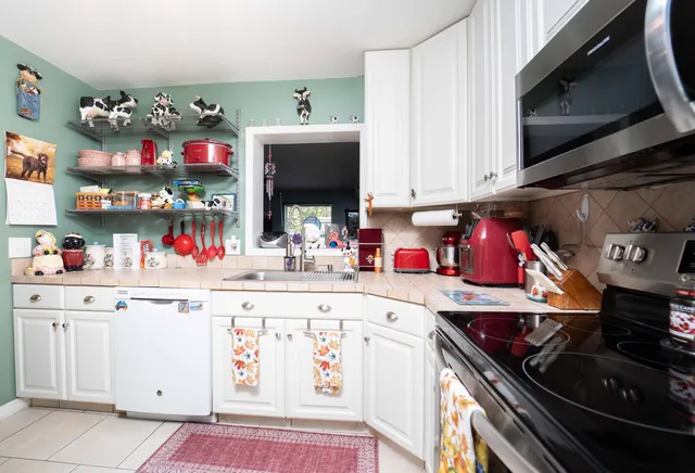 a kitchen with stainless steel appliances kitchen island granite countertop a sink and cabinets