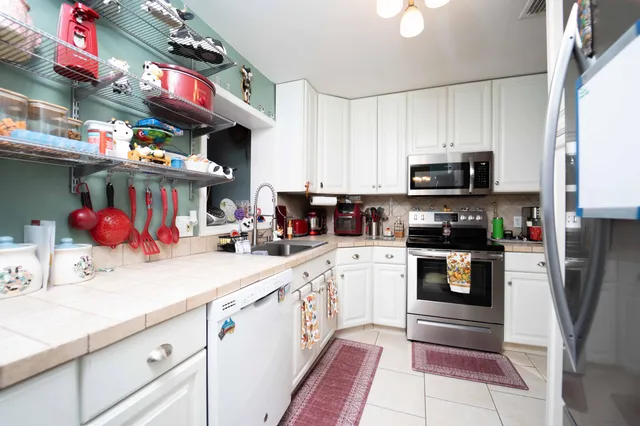 a kitchen filled with stainless steel appliances granite countertop a sink and cabinets