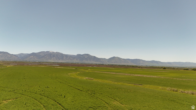 320 South 5400 West Logan, UT 84321 - Photo 15 of 42 Expansive green fields extending towards distant mountains under a clear sky