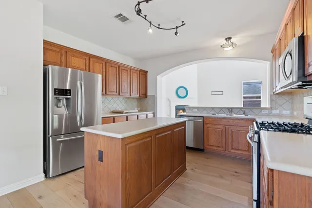 a kitchen that has a sink a stove and a refrigerator