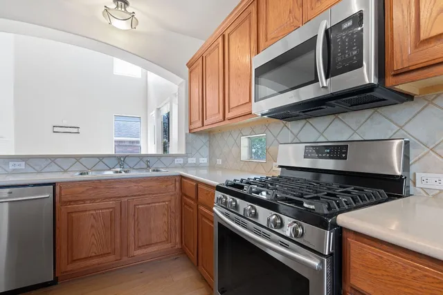 a kitchen with stainless steel appliances granite countertop a stove and a microwave