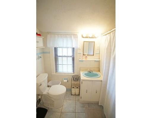 74 Oregon Street Springfield, MA 01118 - Photo 12 of 21 a bathroom with a granite countertop toilet a sink a mirror a window and shower