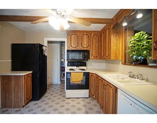 74 Oregon Street Springfield, MA 01118 - Photo 7 of 21 a kitchen with granite countertop a refrigerator a sink dishwasher and wooden cabinets with wooden floor