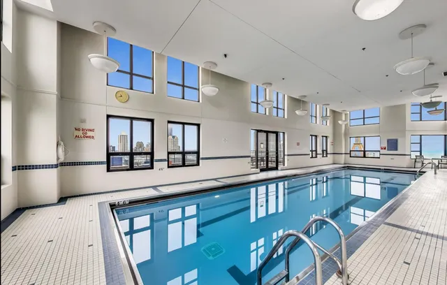 a view of a dining room with furniture a kitchen and chandelier