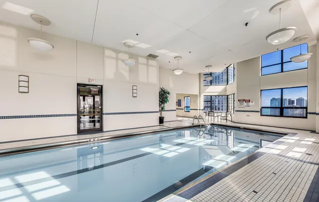 a large white kitchen with stainless steel appliances granite countertop a sink and cabinets
