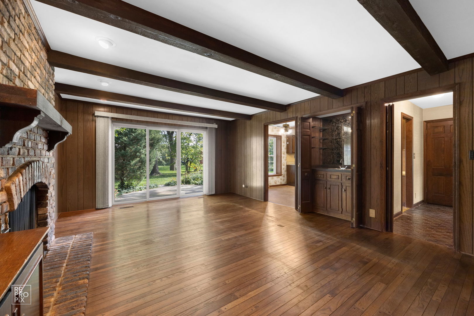 615 Harding Road Hinsdale, IL 60521 - Photo 12 of 32 a view of a hallway with wooden floor and a fireplace