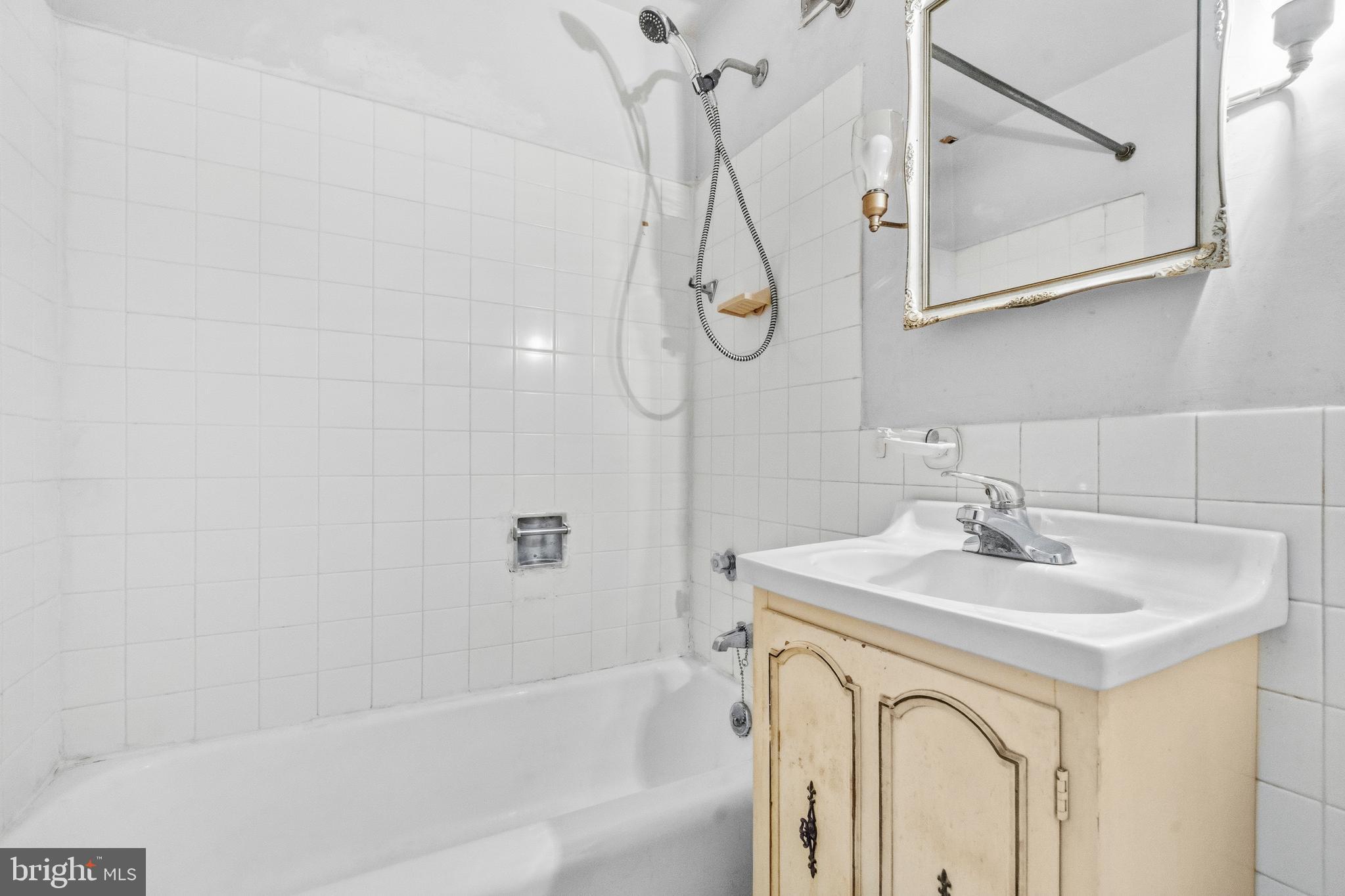 1311 Delaware Avenue Southwest, Unit S240 Washington, DC 20024 - Photo 12 of 25 a bathroom with a sink a mirror and a bathtub
