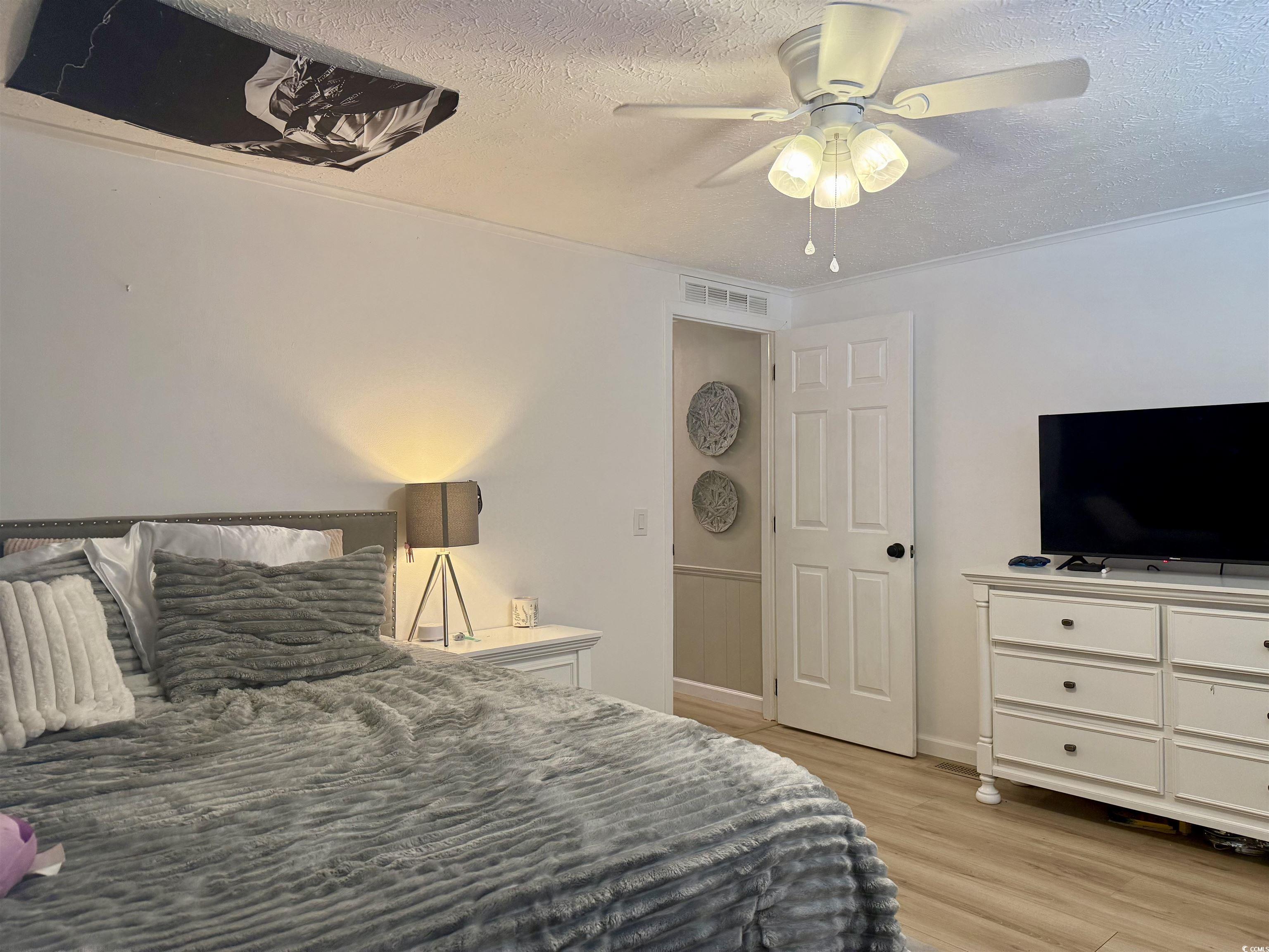 405 Twin Lakes Surfside Beach, SC 29575 - Photo 23 of 36 Bedroom with a textured ceiling, light wood-style floors, and ceiling fan
