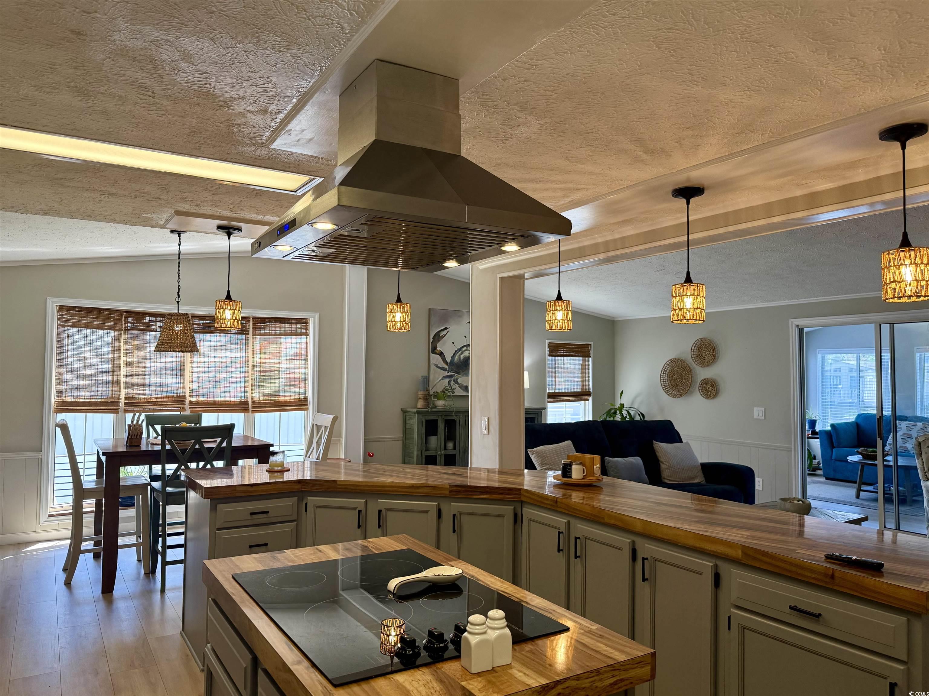405 Twin Lakes Surfside Beach, SC 29575 - Photo 3 of 36 Kitchen featuring wooden counters, a wainscoted wall, decorative light fixtures, a textured ceiling, and island exhaust hood
