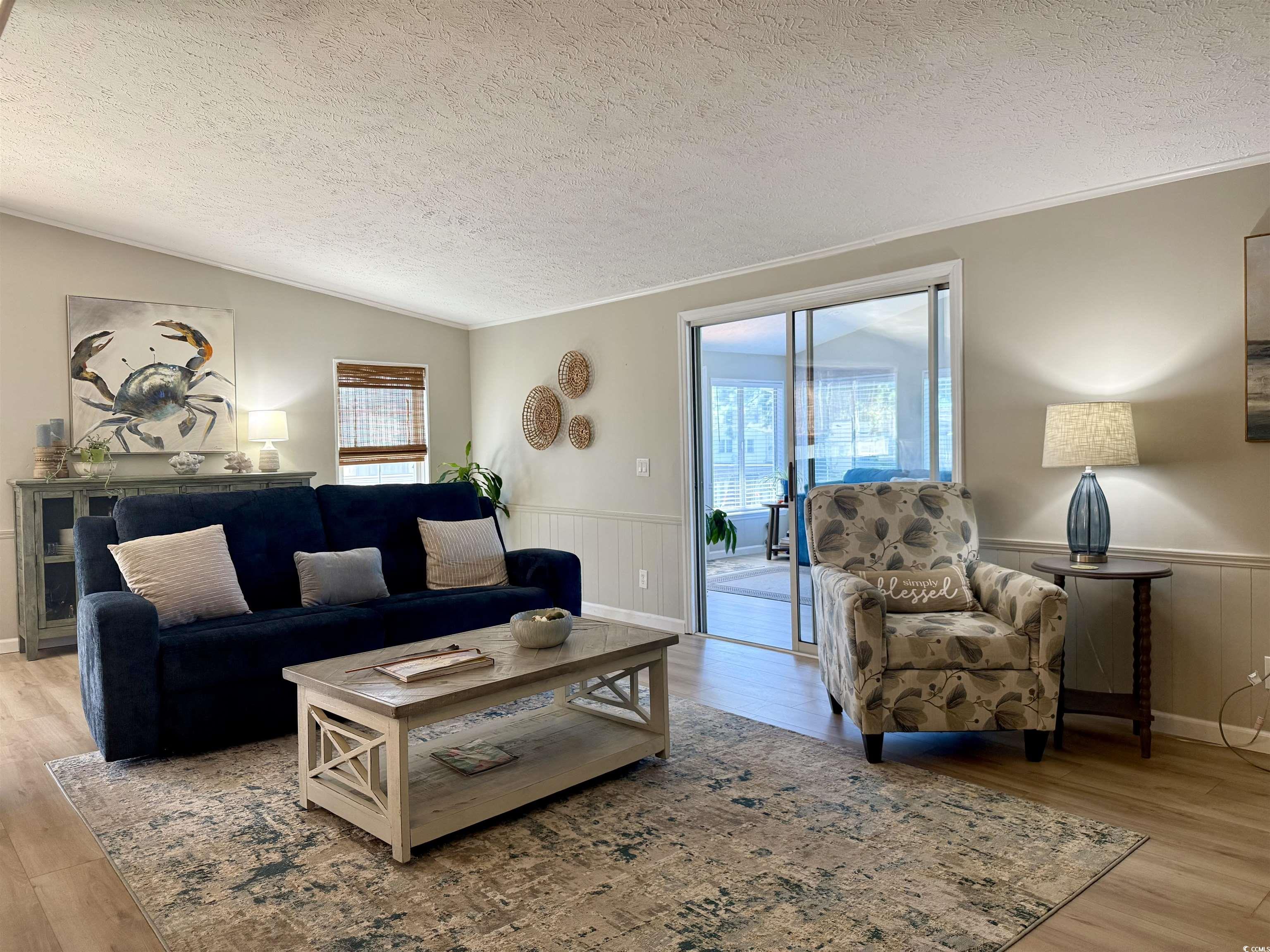 405 Twin Lakes Surfside Beach, SC 29575 - Photo 7 of 36 Living room with a textured ceiling, a wainscoted wall, light wood-style floors, and lofted ceiling