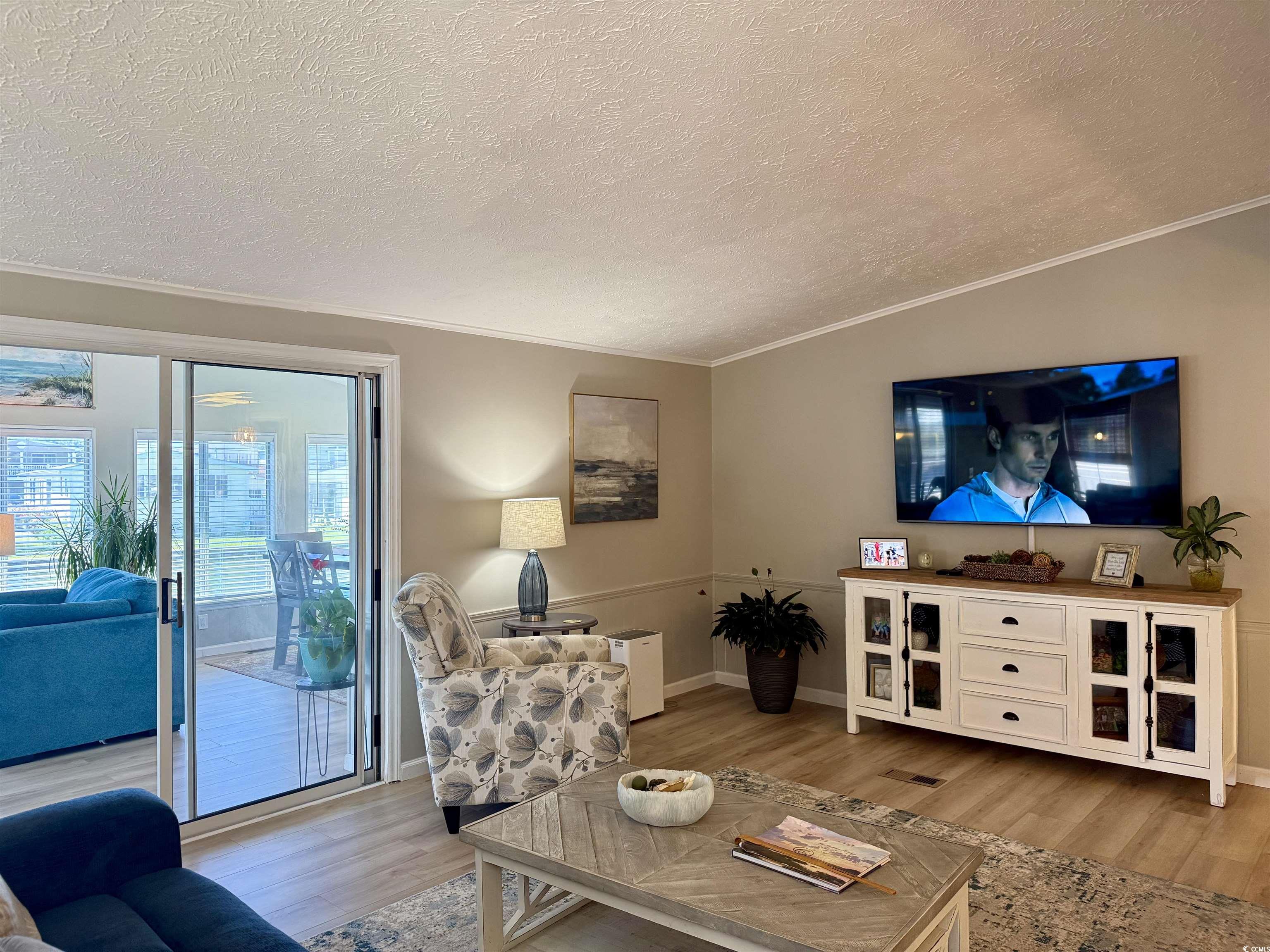 405 Twin Lakes Surfside Beach, SC 29575 - Photo 8 of 36 Living room featuring light wood-style floors, a textured ceiling, and crown molding
