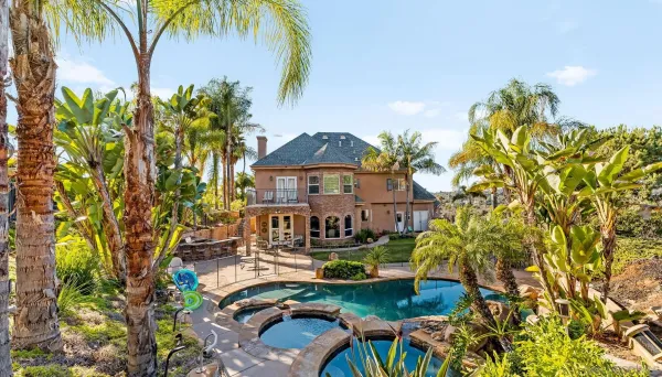 a view of a garden with a table and chairs under an umbrella