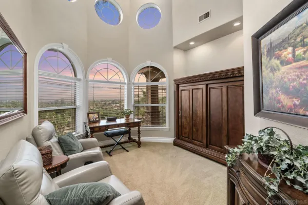 a bed sitting in a spacious bedroom next to a window