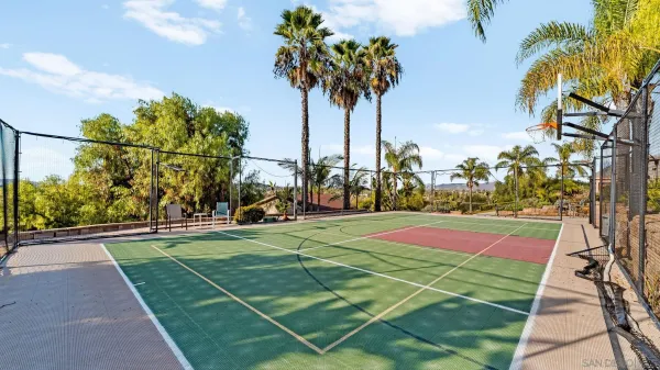 a view of a white house with a yard table and chairs