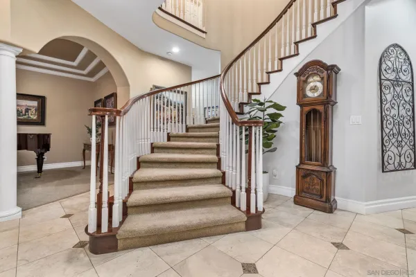 a living room with furniture kitchen view and a chandelier