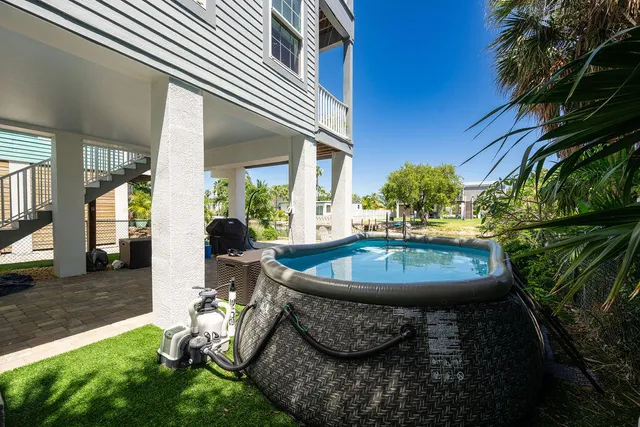 a view of a backyard with table and chairs potted plants and floor to ceiling window