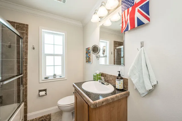 a bathroom with a sink a toilet and a mirror
