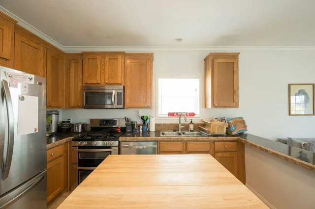 a large kitchen with a large window and stainless steel appliances