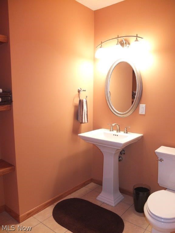 7327 Navarre Road Southwest Massillon, OH 44646 - Photo 18 of 26 Half bath in lower level with tile flooring, pedestal sink and built in shelves.