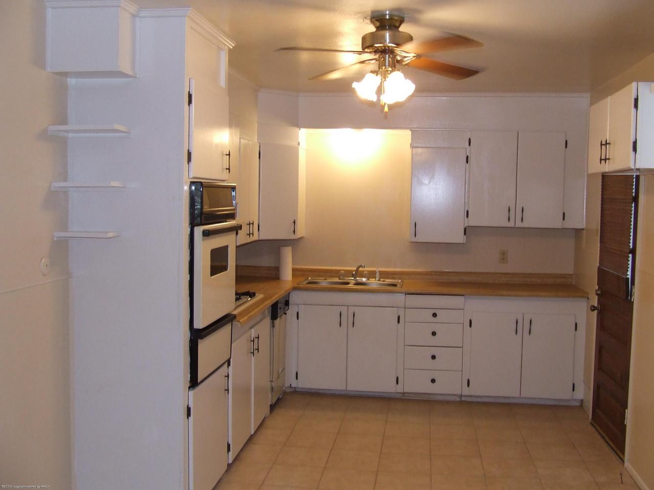4320 South Monroe Street Amarillo, TX 79110 - Photo 3 of 9 a kitchen with granite countertop white cabinets and stainless steel appliances