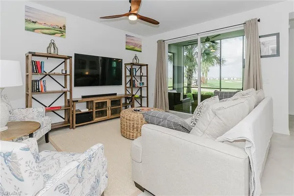 a living room with furniture a flat screen tv and a large window
