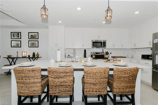 a kitchen with a dining table chairs and refrigerator