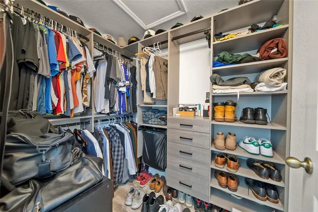 a view of walk in closet with clothes and shoes