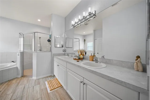 a spacious bathroom with a granite countertop sink a toilet a shower and a mirror