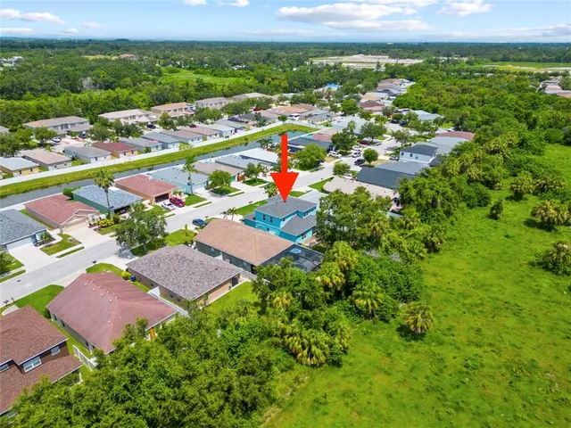 an aerial view of residential houses with outdoor space and trees